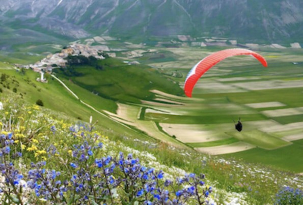 Pessoa fazendo parapente em Castelluccio di Norcia